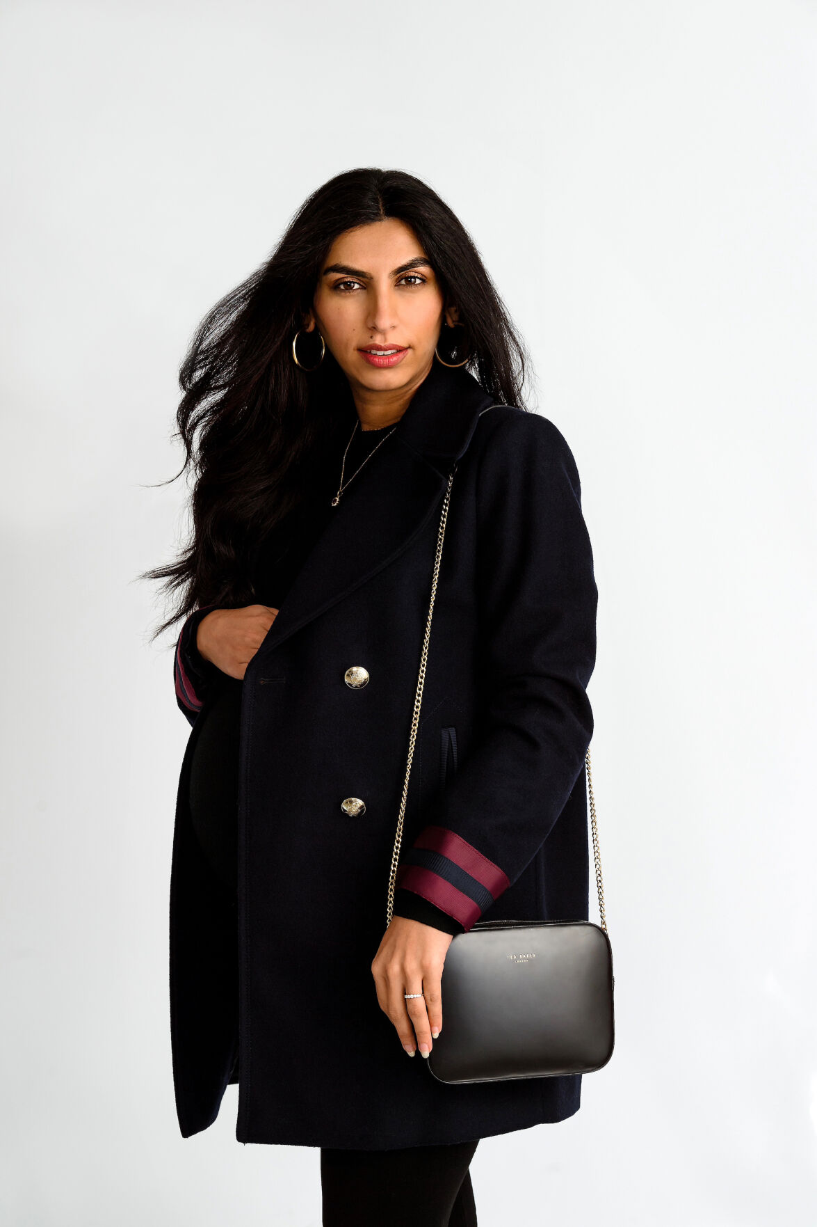 Blue coat: Mango; Black sweater: Banana Republic; Leggings: Hatch; Cross body bag: Ted Baker; Jewelry: Inherited from her mother